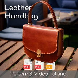 May include: A brown leather handbag with a top handle and a gold-colored clasp. The bag has a rectangular shape with rounded edges and visible stitching. The text "Leather Handbag" is at the top of the image.