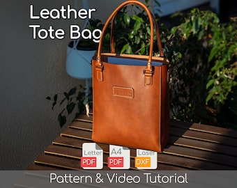 Puede incluir: Un bolso tote de cuero marrón con forma rectangular y dos asas. El bolso tiene un pequeño parche rectangular en la parte delantera. El texto "Leather Tote Bag" está en la parte superior de la imagen. Debajo, iconos con el texto "PDF" y "DXF". El texto "Pattern & Video Tutorial" está en la parte inferior.