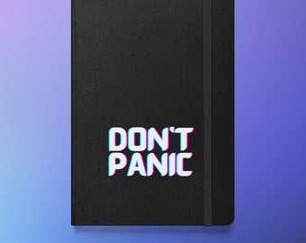 Może przedstawiać: Czarny notatnik z napisem "DON'T PANIC" w kolorze białym z niebieskim i różowym efektem cienia. Notatnik posiada czarne zapięcie na gumkę.