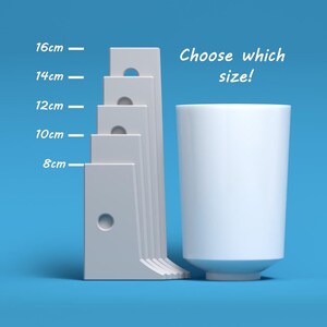 May include: A white ceramic mug next to a set of five white rectangular blocks with holes. The blocks are labelled with measurements in centimetres: 8 cm, 10 cm, 12 cm, 14 cm, and 16 cm. The text "Choose which size!" is written above the mug.
