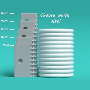 Könnte beinhalten: Ein Stapel weißer Ringe in verschiedenen Größen, neben einem Satz grauer rechteckiger Blöcke mit Löchern. Die Blöcke sind mit Maßen in Zentimetern beschriftet: 8 cm, 10 cm, 12 cm, 14 cm und 16 cm. Der Text "Wählen Sie die Größe!" steht über den Ringen.
