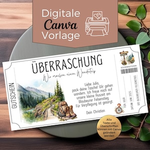 Może przedstawiać: Biały bon upominkowy z niemieckim tekstem "ÜBERRASCHUNG" i "Wir machen einen Wandertrip". Bon zawiera akwarelową ilustrację górskiego szlaku. Na górze bonu znajduje się tekst "Digitale Canva Vorlage".