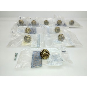 May include: A collection of antique brass cabinet knobs with a spiral design. Each knob is individually packaged in a clear plastic bag. Includes screws for installation. The knobs have a warm, golden hue.