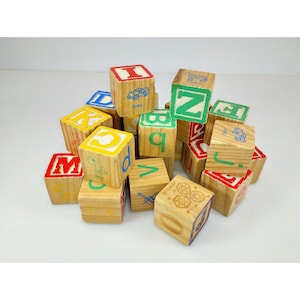 May include: A collection of wooden alphabet blocks featuring various letters in red, green, blue, and yellow. Each block displays a letter and a corresponding illustration, such as a jeep, zebra, dog, and jewels, printed in a simple, colorful style.