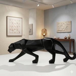Puede incluir: Escultura de pantera negra con diseño geométrico, expuesta en una galería. La escultura está sobre una superficie blanca. La pantera está en posición de caminar, con la cabeza y la cola levantadas.