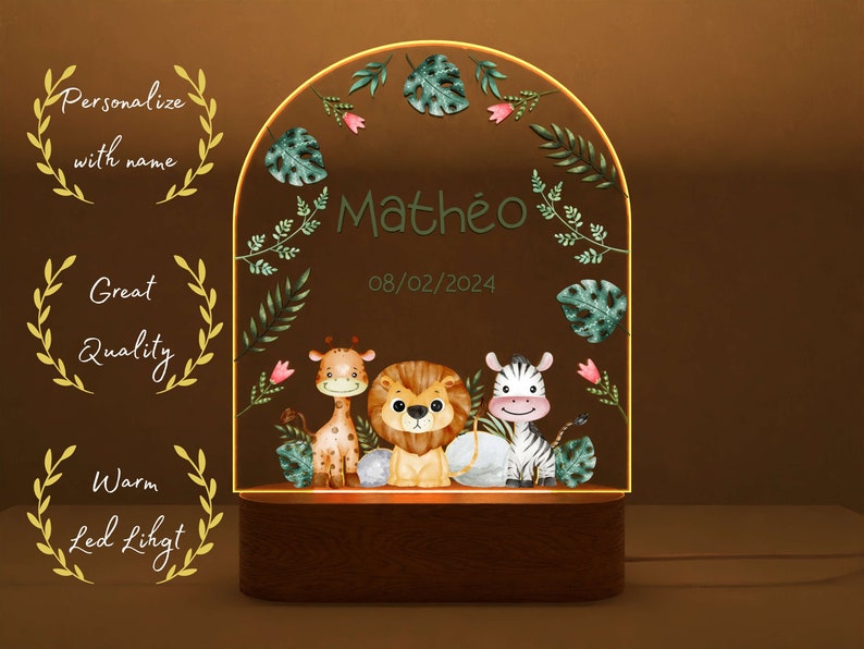May include: A personalised night light with a wooden base and a clear acrylic panel featuring a jungle theme with a giraffe, lion, and zebra. The panel also includes the name "Math&eacute;o" and the date "08/02/2024".