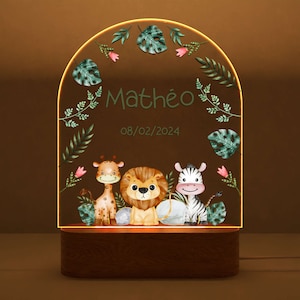 May include: A wooden night light with a clear acrylic insert featuring a giraffe, lion, and zebra with green foliage and the name "Math&eacute;o" and the date "08/02/2024".