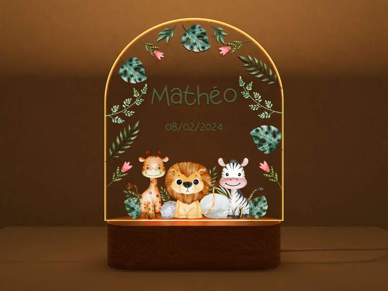 May include: A wooden night light with a clear acrylic insert featuring a giraffe, lion, and zebra with green foliage and the name "Math&eacute;o" and the date "08/02/2024".