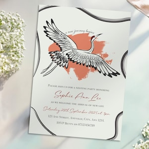 May include: Invitation with a crane illustration. The invitation features a black and white crane design with a coral-colored background. Text includes "a new journey begins" and details for a nesting party honoring Sophie Ann Lee.