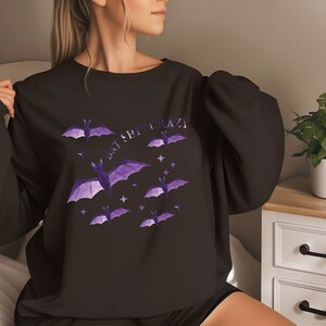 May include: Black sweatshirt with a purple bat graphic and the text "Bat Shit Crazy".