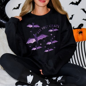 May include: Black sweatshirt with a purple bat graphic and the text "Bat Shit Crazy".