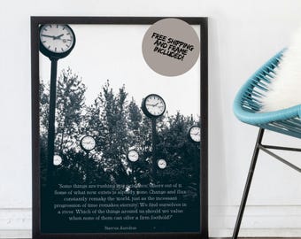 May include: Black framed art print featuring a surreal landscape with clock-topped poles amidst trees. The print includes a quote by Marcus Aurelius. A gray circle with text is in the upper right corner.