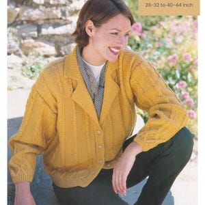 May include: A woman wearing a mustard yellow knitted cardigan with a collared neckline and button closure. The cardigan has a textured cable knit design. The text "DK / 8 Ply", "3 sizes", and "28-32 to 40-44 inch" (71-81 to 102-112 cm) are visible.