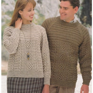 May include: Two people wearing knitted jumpers with cable knit patterns. The jumper on the left is beige and the jumper on the right is brown. DK / 8 Ply 28 to 46 ins