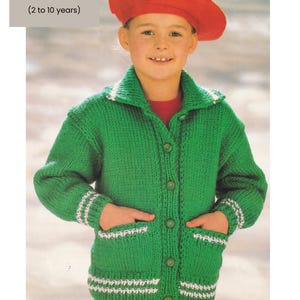May include: A green knitted cardigan with white trim and pockets, worn with a red beret. The cardigan is designed for children aged 2 to 10 years, with a chest size of 22 to 30 inches. The yarn is chunky/bulky.