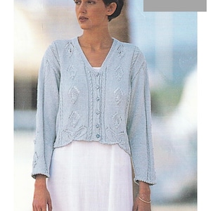May include: A light blue knitted cardigan with a V-neck and button closure. The cardigan features a decorative pattern and is designed for a 30 to 40 inch bust. The image also includes the text "DK / 8 Ply".