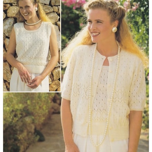 Puede incluir: Un cárdigan blanco de punto y un top sin mangas a juego con un delicado patrón de calado. El cárdigan tiene cierre de botón y mangas cortas. La modelo lleva un collar de perlas.