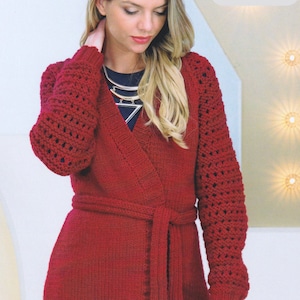 May include: A red knitted cardigan with a wrap front and a matching tie belt. The cardigan has a chunky knit texture and openwork detailing on the sleeves. The cardigan is 28/30 - 44/46 inches in length.