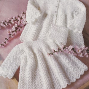 May include: White knitted baby cardigan and dress set, made with DK and 4 ply yarn. The set is designed for babies 16 to 20 inches (newborn to 12 months).