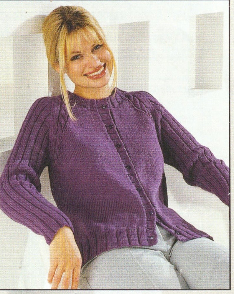 Op de afbeelding: Een paarse cardigan met een knoopsluiting en ribbeldetails. De cardigan heeft een ronde hals en lange mouwen.