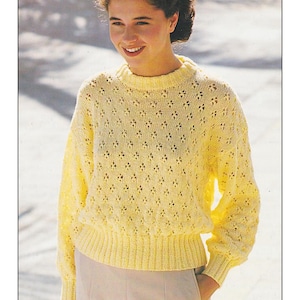 Op de afbeelding: Een gele gebreide trui met een kantpatroon. De trui heeft een ronde hals en lange mouwen. DK / 8 Ply 28 tot 40 inch borstomvang.