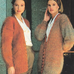 May include: Two women wearing long, open mohair cardigans in shades of orange and brown. The cardigans have pockets and button closures. The text "Mohair & DK 28 - 38/40 ins" is visible in the upper right corner.