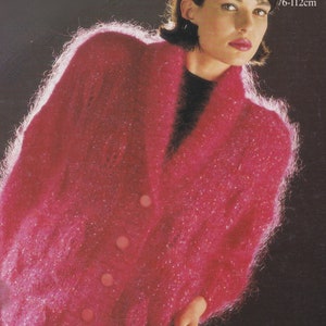 Może przedstawiać: Różowy kardigan z moheru zapinany na guziki. Kardigan jest puszysty i ma luźny krój. W obrazie widoczny jest tekst "30-44 inch 76-112cm".