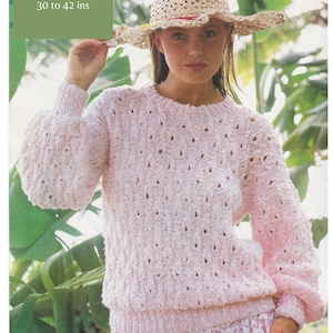 以下が含まれることがあります： レース模様のピンクのセーター。ストローハットとピンクと白のストライプの入ったスカートを着用した人が着ています。このセーターは太い糸で編まれており、長さは30〜42インチです。