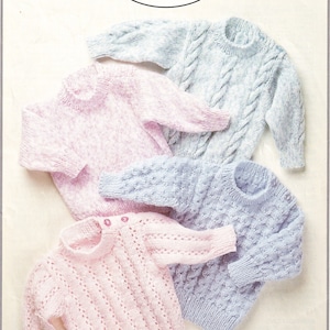 May include: Four knitted baby sweaters in pink and blue. The sweaters are laid out on a white background. The sweaters are all different styles, with one featuring a cable knit pattern, one with a textured stitch, and two with a lacy stitch. The sweaters are all for babies aged 18-28 inches (46-71 cm).