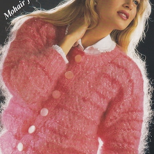 Könnte beinhalten: Ein rosa Mohair-Cardigan mit Knopfleiste. Der Cardigan ist flauschig und hat ein zartes Strickmuster. Der Text "Mohair fashion" ist in der oberen linken Ecke des Bildes sichtbar.