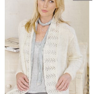 May include: A white mohair cardigan with a delicate lace pattern. The cardigan is open at the front and has long sleeves. It is worn over a grey tank top and blue jeans. The text "Mohair 32 to 54 ins" is visible in the top right corner of the image.