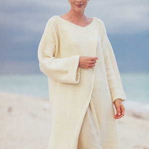 May include: A white knitted cardigan with a long, open front and long sleeves. The cardigan is made of a chunky yarn and has a simple, classic design. Merino Chunky / Bulky 32/34 - 40/42 ins
