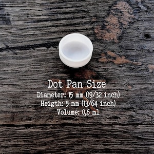 Puede incluir: Un peque&ntilde;o recipiente circular blanco con un di&aacute;metro de 15 mm, una altura de 5 mm y un volumen de 0,6 ml. El texto Dot Pan Size, Diameter: 15 mm (19/32 inch), Height: 5 mm (13/64 inch), Volume: 0,6 ml aparece en la imagen.