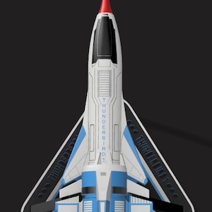 Puede incluir: Una nave espacial blanca y azul con una nariz roja, etiquetada como "THUNDERBIRD 1", está en una plataforma de aterrizaje triangular negra.