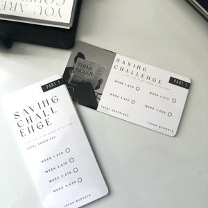May include: Two white rectangular saving challenge cards with black text and a black and white photo of a person reading a newspaper. The cards feature the text Saving Challenge, Part 1, Think Bigger, and Javan Budgets, with checkboxes for weeks 1 through 4.