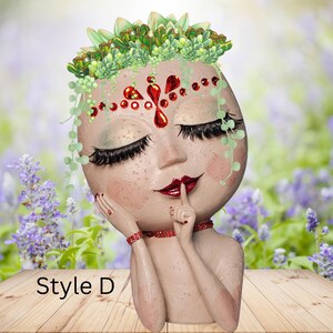 May include: A white ceramic planter shaped like a woman's face with closed eyes and a finger to her lips. The planter has a red and green succulent plant growing out of the top of her head. The planter is labeled "Style D".