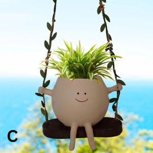 Maceta colgante Happy Face en columpio retocada y adornada con hojas verdes de tela de doble cara (estilo C). 7 estilos más para elegir.
