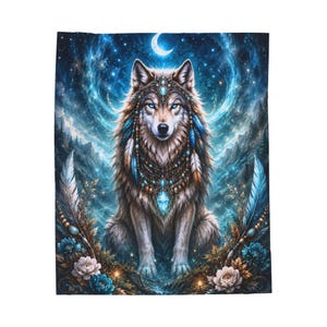 Peut inclure: Une couverture rectangulaire illustrée d'un loup orné d'une coiffe perlée, de plumes et de cristaux bleus. L'arrière-plan représente un croissant de lune, une nébuleuse bleue tourbillonnante, des montagnes et des motifs floraux.