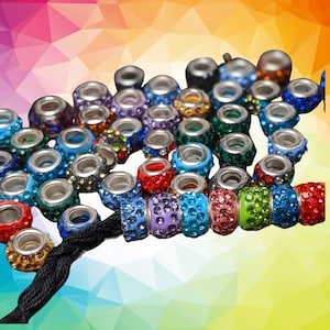 May include: A collection of colorful, faceted glass beads with silver metal accents. The beads are strung on a black cord and are perfect for jewelry making.