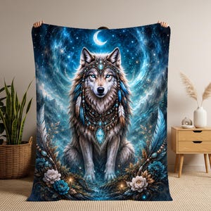 Peut inclure: Une couverture rectangulaire ornée d'une illustration centrale représentant un loup paré de plumes bleues et brunes, de perles et d'une grosse pierre précieuse bleue. Le fond montre un ciel étoilé avec un croissant de lune, des montagnes et des fleurs.