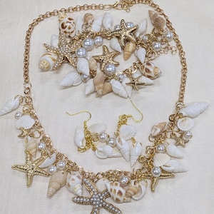 Handmade seashell necklace and earrings set with matching bracelet featuring real shells, pearl beads, and gold starfish charms.