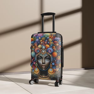 Puede incluir: Una maleta negra con ruedas que presenta un estampado gráfico vibrante y colorido de una persona con patrones intrincados y arremolinados en tonos azul, naranja, rojo y amarillo alrededor de la cabeza. Tiene un asa negra y cuatro ruedas.