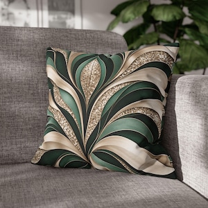 Peut inclure: Un coussin carré arborant un motif abstrait répétitif composé de formes courbes vert foncé, crème et à paillettes dorées. Le design se compose de segments superposés en éventail qui rayonnent depuis le centre de la housse.