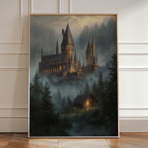 May include: A framed print of a castle nestled in a misty forest. The castle is illuminated with warm light, and a small cottage glows in the foreground. The artwork has a fantasy theme, with dark green trees and a moody atmosphere.