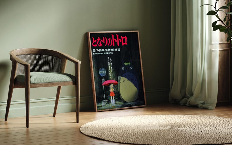 May include: A framed poster featuring Japanese text and a cartoon illustration of a girl with an umbrella and a large, round creature. A wooden chair with a woven back and a round, woven rug are also in the image.