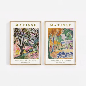 Puede incluir: Dos impresiones enmarcadas de pinturas de Henri Matisse, ambas tituladas "Paisaje en Collioure". La impresi&oacute;n de la izquierda muestra un paisaje con un gran &aacute;rbol en primer plano y una vista de un pueblo en la distancia. La impresi&oacute;n de la derecha muestra un paisaje con una vista del mar en la distancia. Ambas impresiones est&aacute;n en un marco dorado.