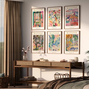 Puede incluir: Seis impresiones de arte enmarcadas de coloridas pinturas de paisajes de Henri Matisse. Las impresiones est&aacute;n dispuestas en dos filas de tres, con el nombre del artista y el t&iacute;tulo de cada obra impresos debajo de la imagen. Las impresiones se muestran en una pared sobre una mesa consola de madera.