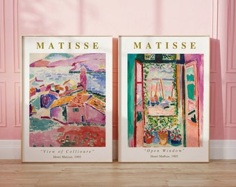 May include: Two framed art prints of paintings by Henri Matisse. The first print is titled "View of Collioure" and depicts a colorful landscape with a town and a body of water. The second print is titled "Open Window" and shows a view of a window with a red frame and a colorful scene outside.