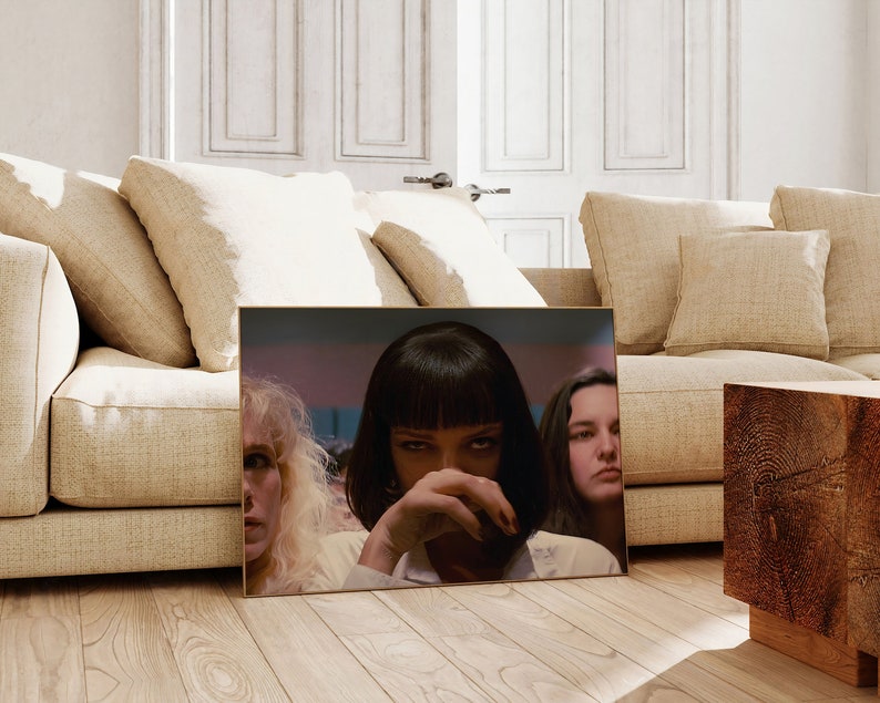 May include: A framed movie poster featuring three women. The woman in the center has dark hair and is looking directly at the viewer. The woman on the left has blonde hair and is looking to the right. The woman on the right has dark hair and is looking to the left.