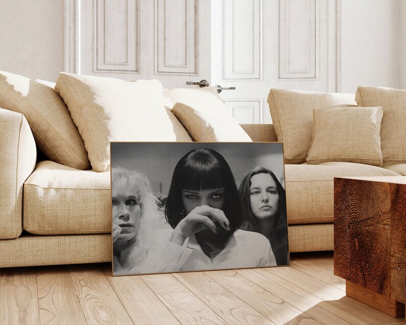 May include: Black and white photograph of three women. The woman in the center has short black hair and is looking at the camera. The woman on the left has blonde hair and is looking to the right. The woman on the right has brown hair and is looking to the left.